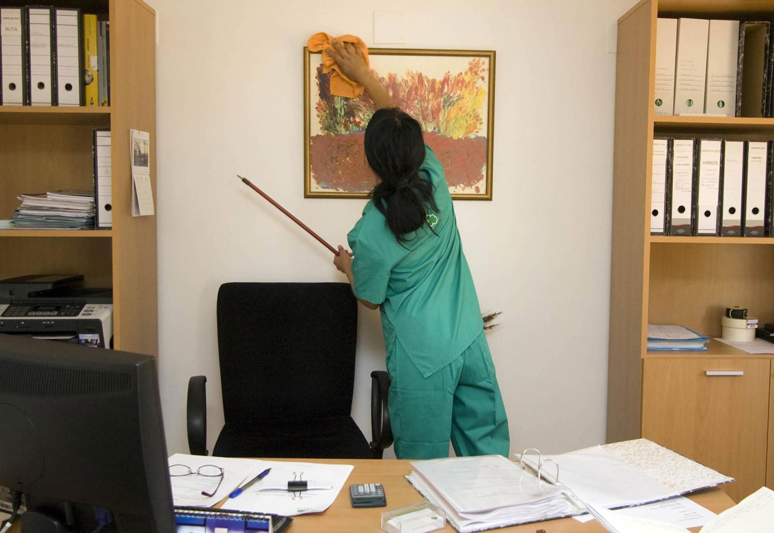 Mantenimientos y Contratas Alonso S. L. mujer haciendo limpiando cuadro en la pared